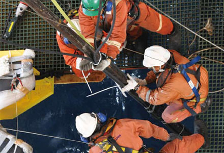 The monitoring system is assembled while being lowered into the sea. For safety, all work on CHIKYU around the moon pool is carried out by crew and staff wearing lifelines.