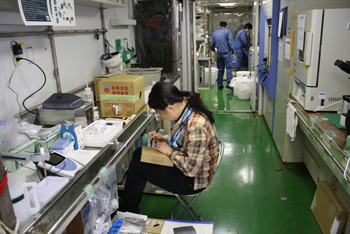 ウェットラボ（堆積物を取り扱う研究室）で準備作業を行う研究者