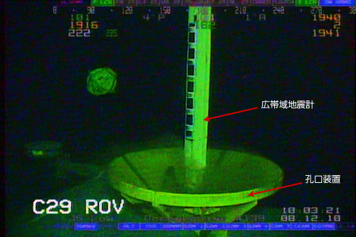 【写真】長期孔内観測装置の掘削孔内への降下（無人探査機にて海底作業の様子を撮影　平成22年12月8日）