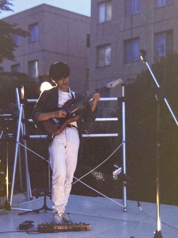 学生時代のステージでギターを演奏している生田さん