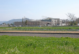 春の田園風景と高知コアセンターの外観。