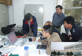 WFSDの実験室において，中国の共同研究者に実験手順の説明を説明する研究者。