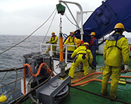 外部救難訓練で救難目標に使用する潜水船ダミートランスポンダ（写真中央のオレンジ色の筒上の物体）の投入。