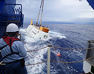 海面から吊り上げられた「しんかい6500」がインド洋のおおきなうねりに飲み込まれます。